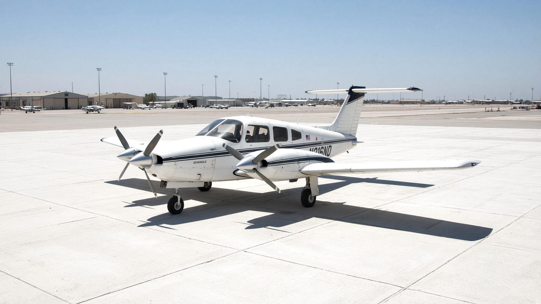 Light twin-engine trainer on a bleached noon ramp, two propellers, harsh sun