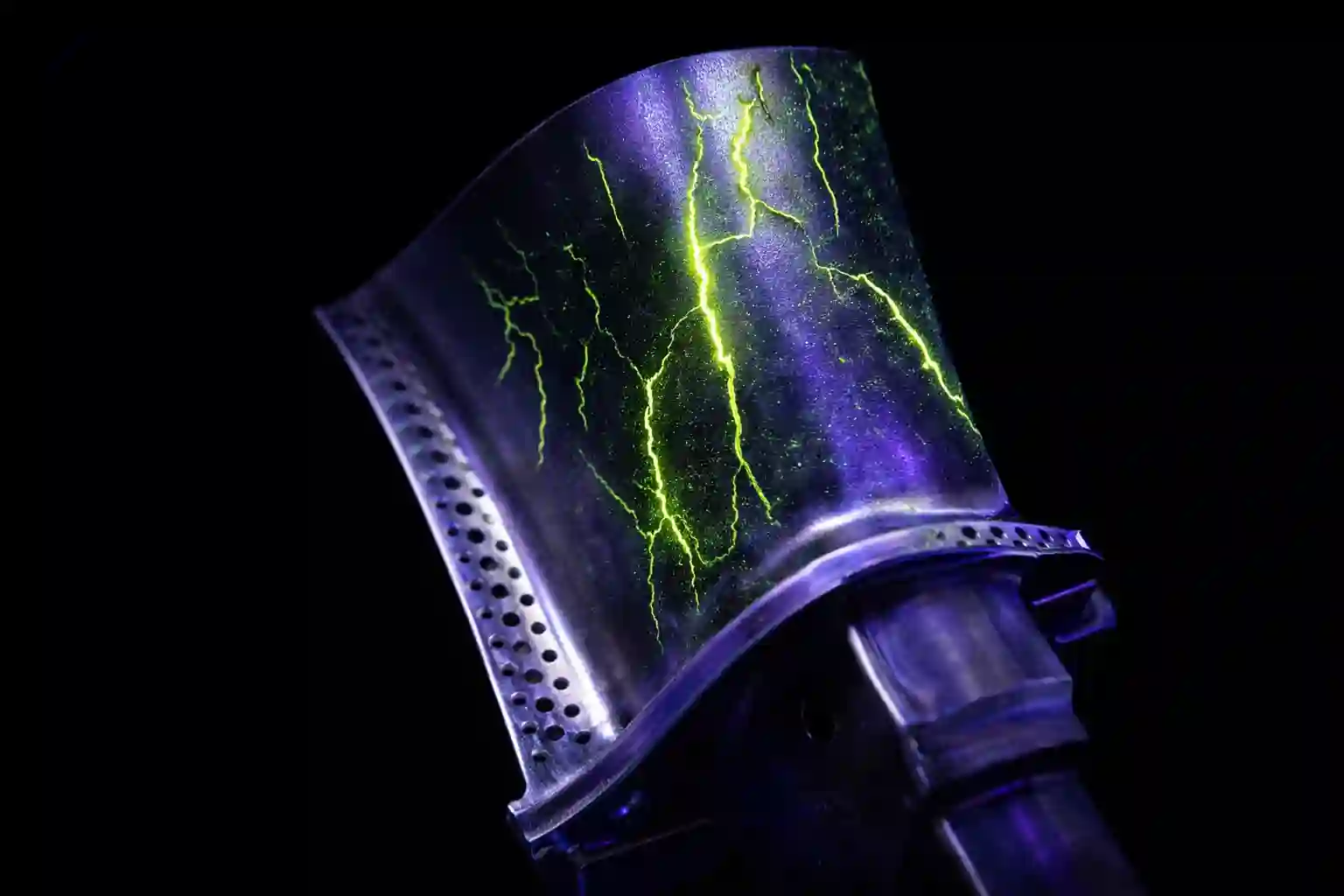 Titanium turbine blade revealing cracks under UV light using Liquid Penetrant Inspection equipment.